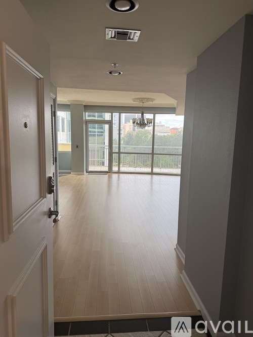 A hallway with a door on the left and a balcony on the right.