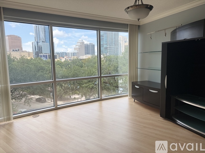 A living room with a large window overlooking a cityscape.