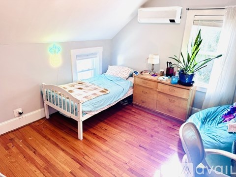 A bedroom with a bed, dresser, and window.