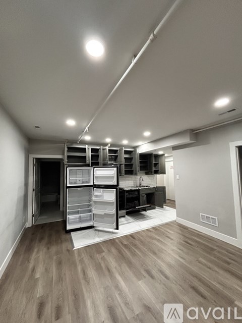 A kitchen with a refrigerator, sink, and cabinets is available for rent.