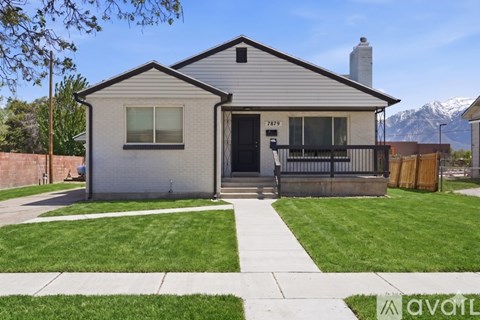A house with a grey exterior and a black door is shown.