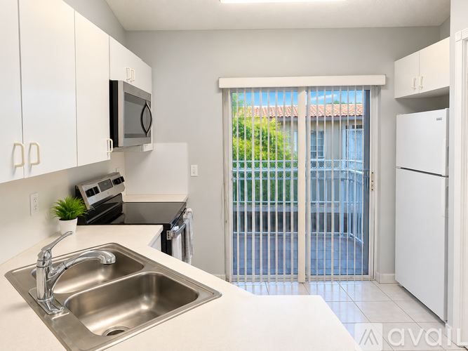 A kitchen with white cabinets and a stainless steel sink.