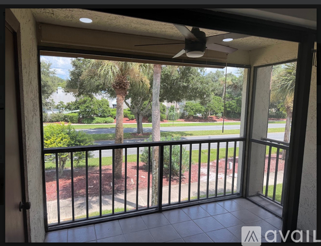 A balcony with a black railing and a ceiling fan.