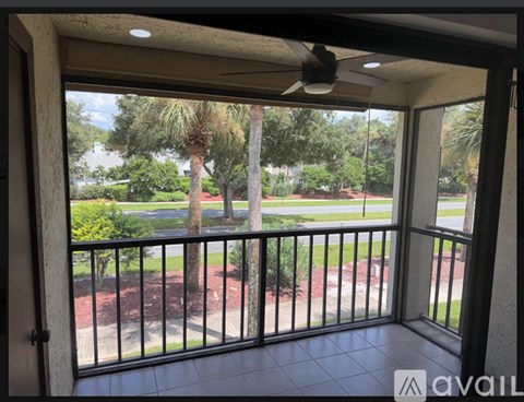 A balcony with a black railing and a ceiling fan.