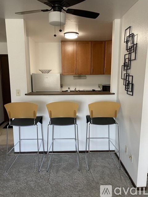 A kitchen with a bar stool and a ceiling fan.