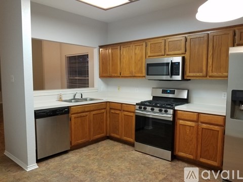 A kitchen with wooden cabinets and stainless steel appliances.
