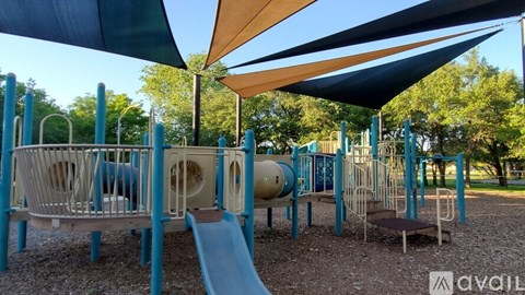 A playground with a blue slide and a yellow canopy.