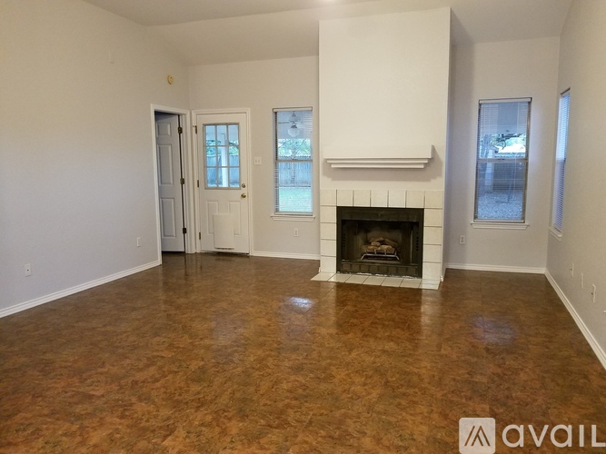 A living room with a fireplace and a door to another room.