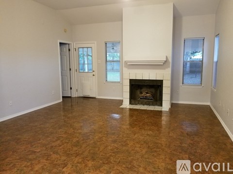A living room with a fireplace and a door to another room.