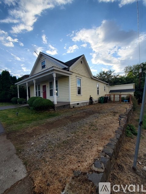 A house with a red door and a porch is for sale.