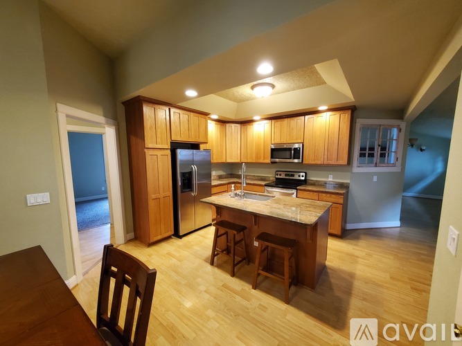 A kitchen with wooden cabinets and a table with chairs.