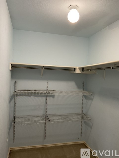 A small room with a shelving unit and a light on the ceiling.