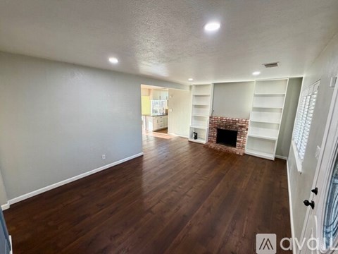 A living room with a fireplace and built-in shelves.