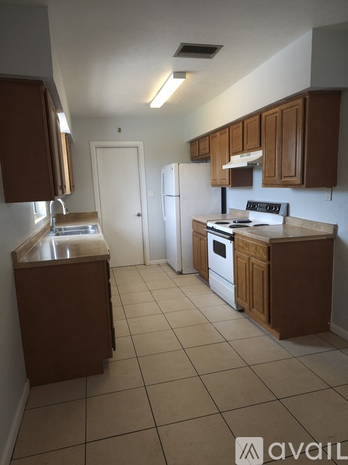 A kitchen with brown cabinets and white appliances.