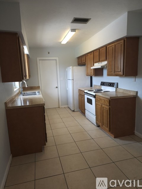 A kitchen with brown cabinets and white appliances.