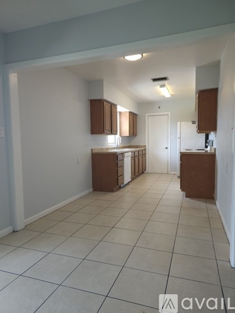 A kitchen area with white cabinets and a white door.