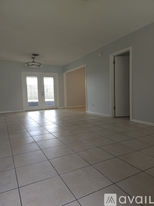 A spacious room with tiled flooring and a ceiling fan.