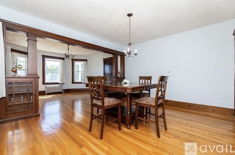 A dining room with a wooden table and chairs.