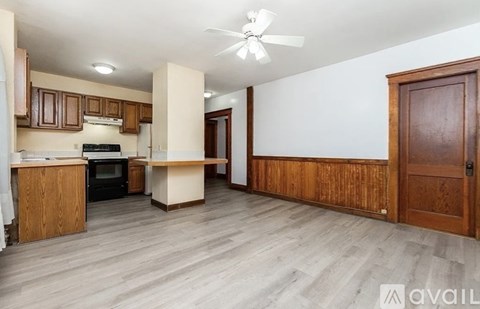 A kitchen with wooden cabinets and a black oven.