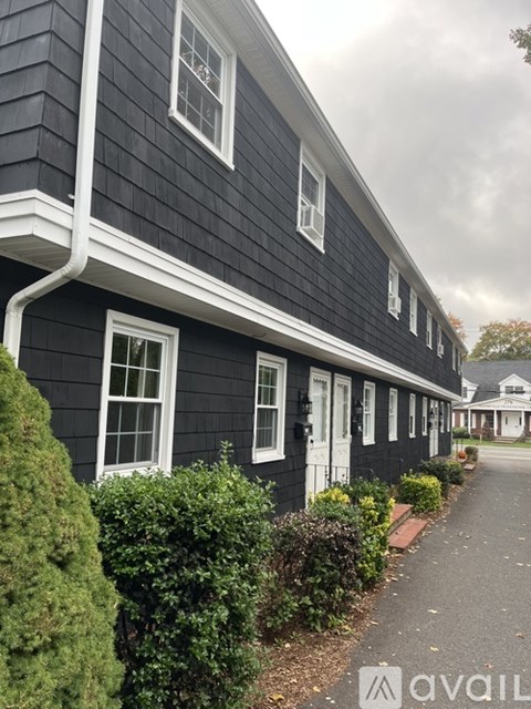 A row of houses with a sidewalk in front.