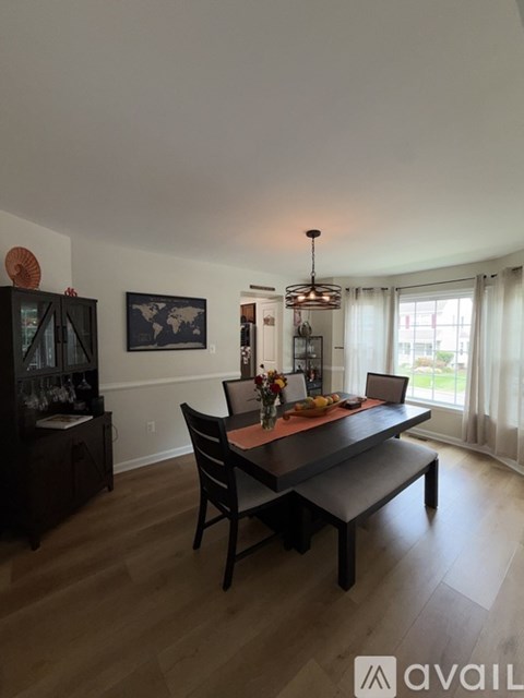 A dining room with a wooden table and chairs.