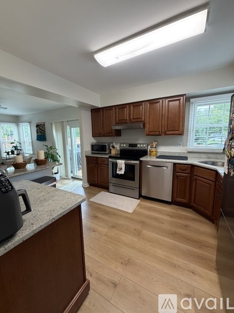 A kitchen with wooden cabinets and a granite countertop.