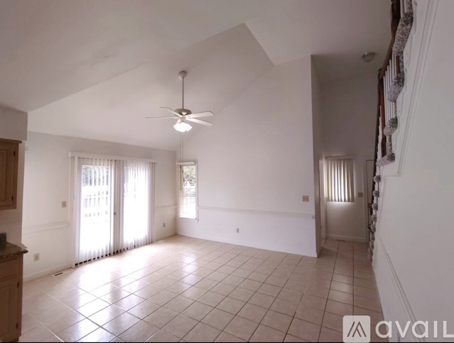 A spacious room with a ceiling fan and tiled flooring.