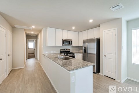 A kitchen with white cabinets and a granite countertop.