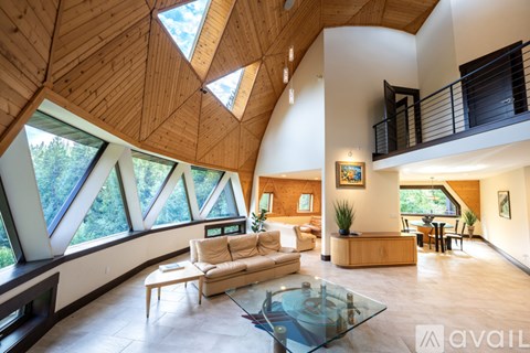 A modern living room with a glass table and a skylight.