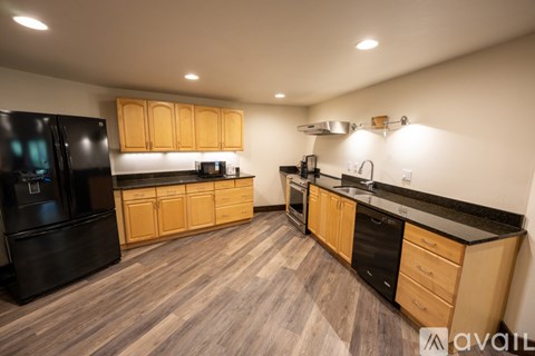 A kitchen with wooden cabinets and black appliances.