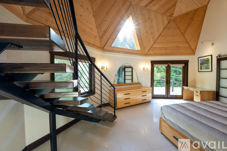 A bedroom with a large bed and a staircase.