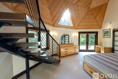 A bedroom with a large bed and a staircase.