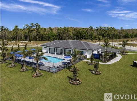 A house with a pool surrounded by a fence and trees.