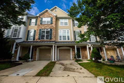 A large house with a stone pillar in front.
