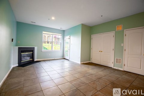 A living room with a fireplace and tile flooring.