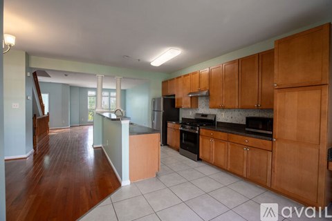 A kitchen with wooden cabinets and a black countertop.