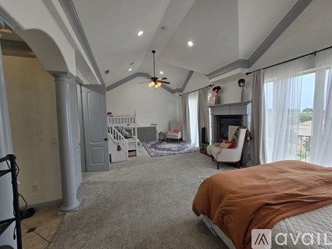A bedroom with a large bed and a fireplace.