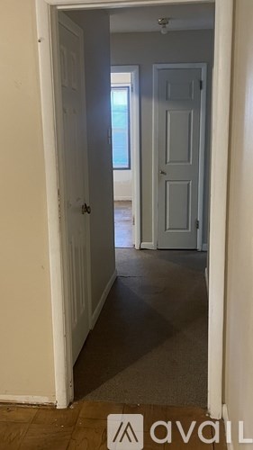 A hallway with a door on the left and a door on the right.