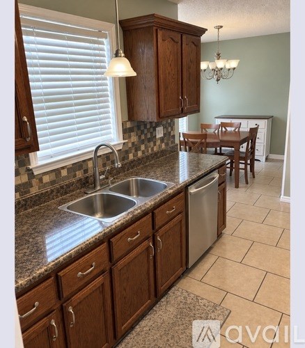 A kitchen with wooden cabinets and a granite countertop.