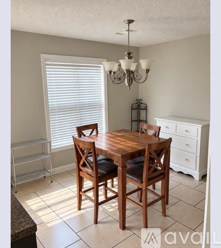 A dining room with a wooden table and chairs.
