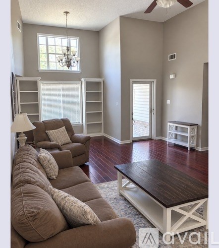 A living room with a brown couch and a wooden coffee table.