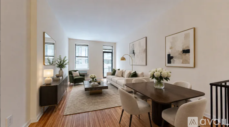 A modern living room with a dark wood floor and white walls.
