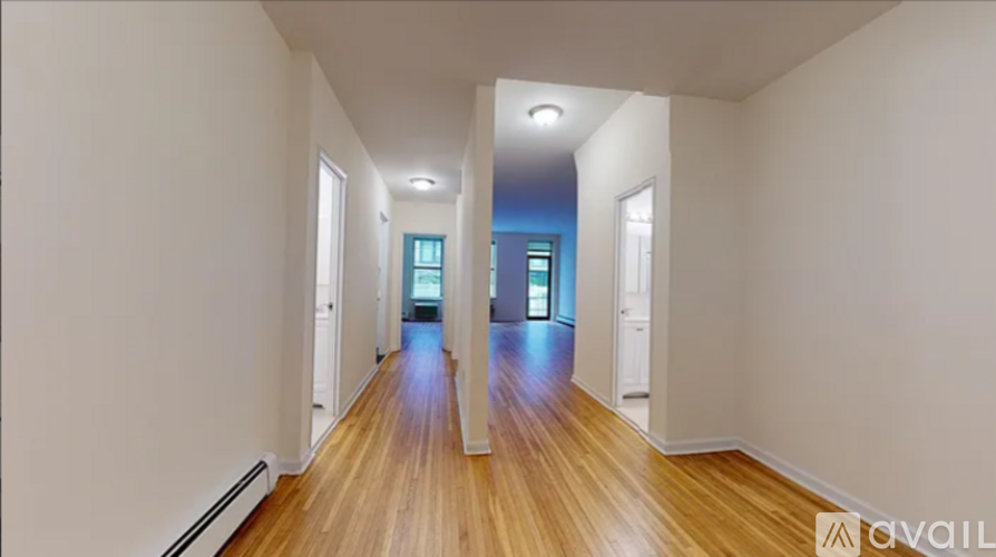 A long hallway with wooden floors and white walls.