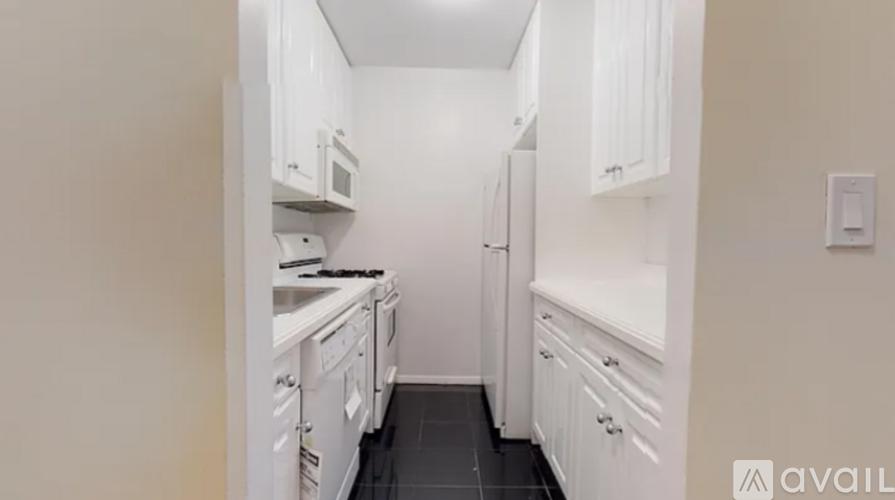 A kitchen with white cabinets and appliances.