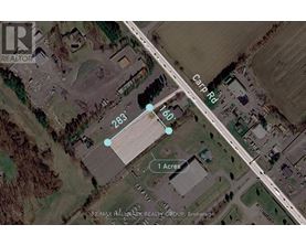 An aerial view of a property with a 1 acre plot and a road passing through it.
