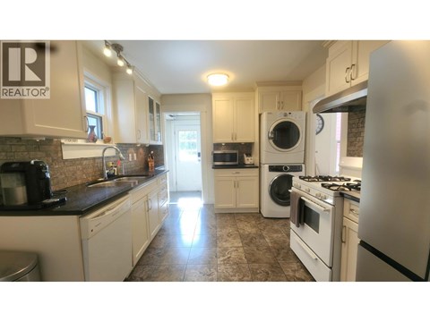 A kitchen with a washing machine and a fridge.