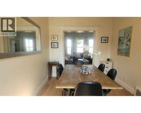 A dining room with a wooden table and chairs.