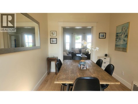 A dining room with a wooden table and chairs.