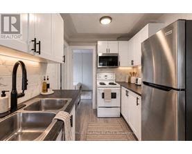 A modern kitchen with stainless steel appliances and white cabinets.