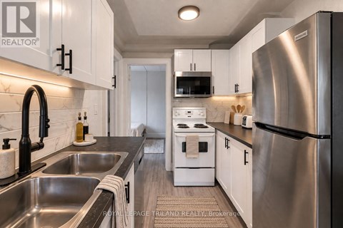 A modern kitchen with stainless steel appliances and white cabinets.